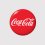 Coca-Cola-Logo von 2007 mit ikonischer weißer Schrift im stilvollen roten, glänzenden Kreisdesign auf grauem Hintergrund.