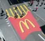 Kreative McDonald’s-Werbung auf einer Straße: Zebrastreifen als Pommes in einer roten McDonald’s-Verpackung gestaltet, Passanten überqueren die Straße.